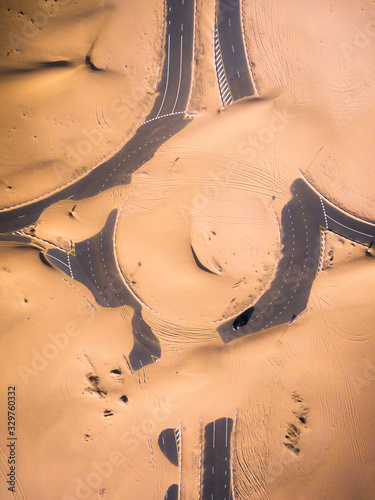 Aerial birds eye view of roudabout road covered in sand during summer photo