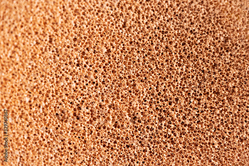 Make-up sponge close-up texture. Macro porous beige background