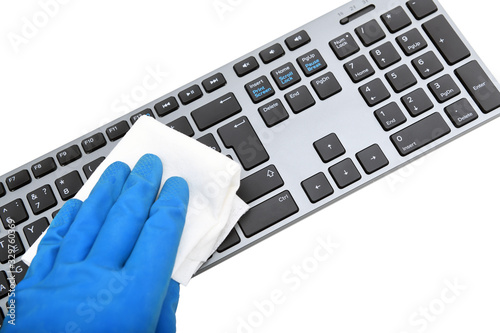 Worker's hand wipes dust and dirt on the keyboard. A maid or housewife takes care of the house. General, regular cleaning. The concept of a commercial cleaning company photo