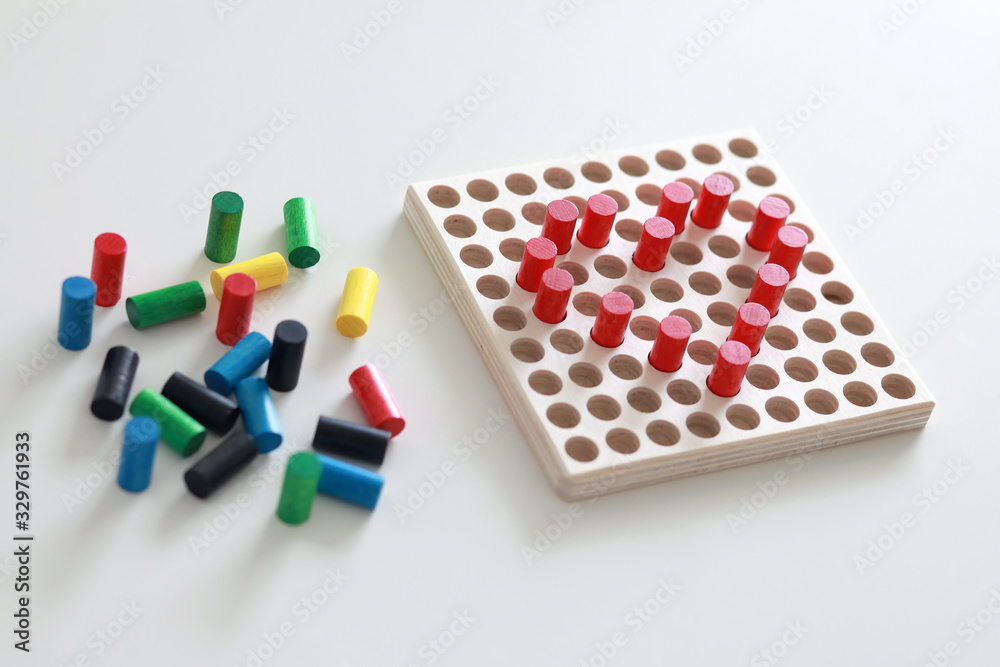 Bright rainbow coloured educational wooden toy. Preschool toy for toddlers. Wooden peg board game with colourful pegs to develop fine motor skills and creativity. Bright rainbow coloured educational wooden toy. Preschool toy for toddlers. Wooden peg board game with colourful pegs to develop fine motor skills and creativity.