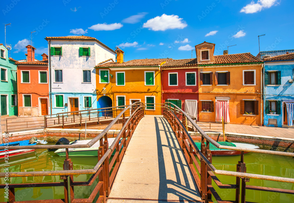 Venice landmark, Burano island canal, bridge, colorful houses and boats, Italy.