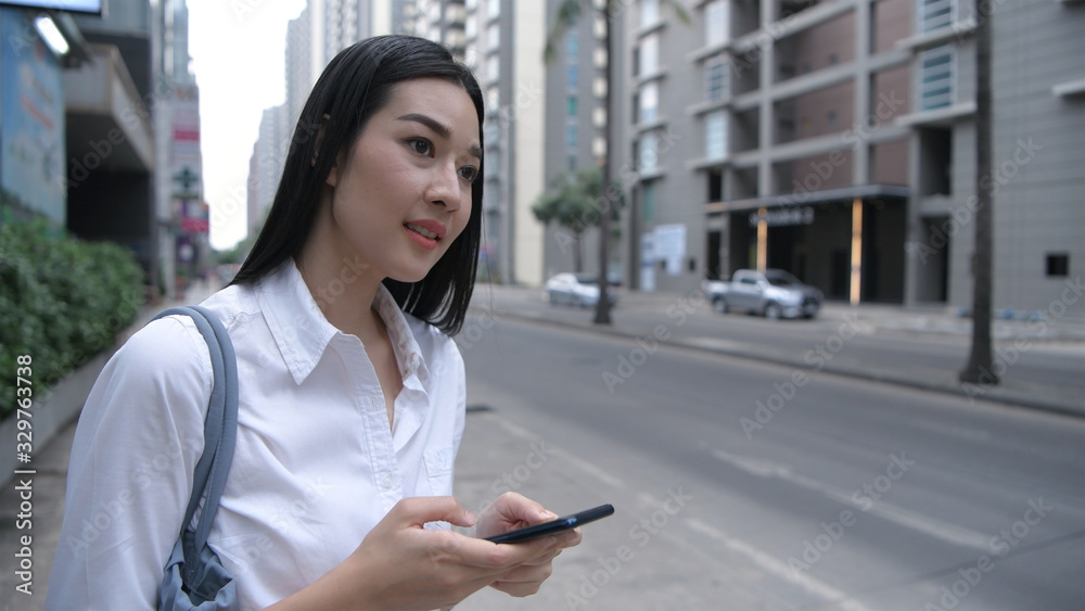 Travel Concept. The woman is using the application to call a taxi to get to work. 4k Resolution.