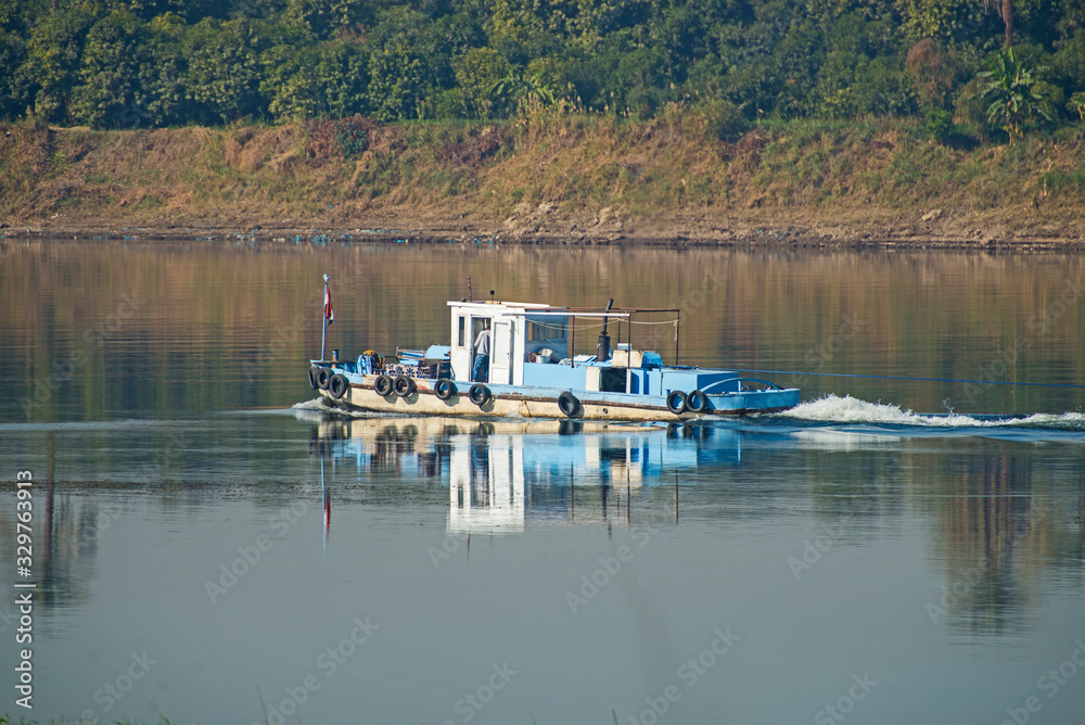 Old traditional river tug boat traveling through rural african landscape Old traditional river tug boat traveling through rural african landscape