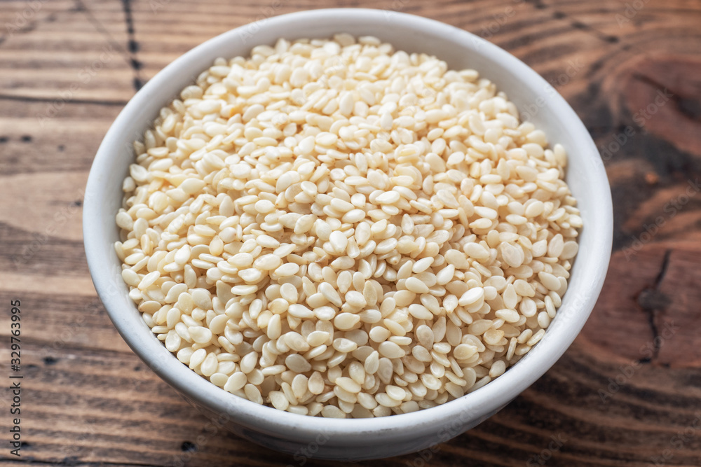 Organic natural sesame seeds on wooden spoon Organic natural sesame seeds on wooden spoon