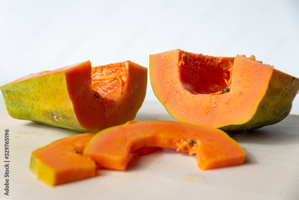 Sliced papaya on a white cutting board Sliced papaya on a white cutting board