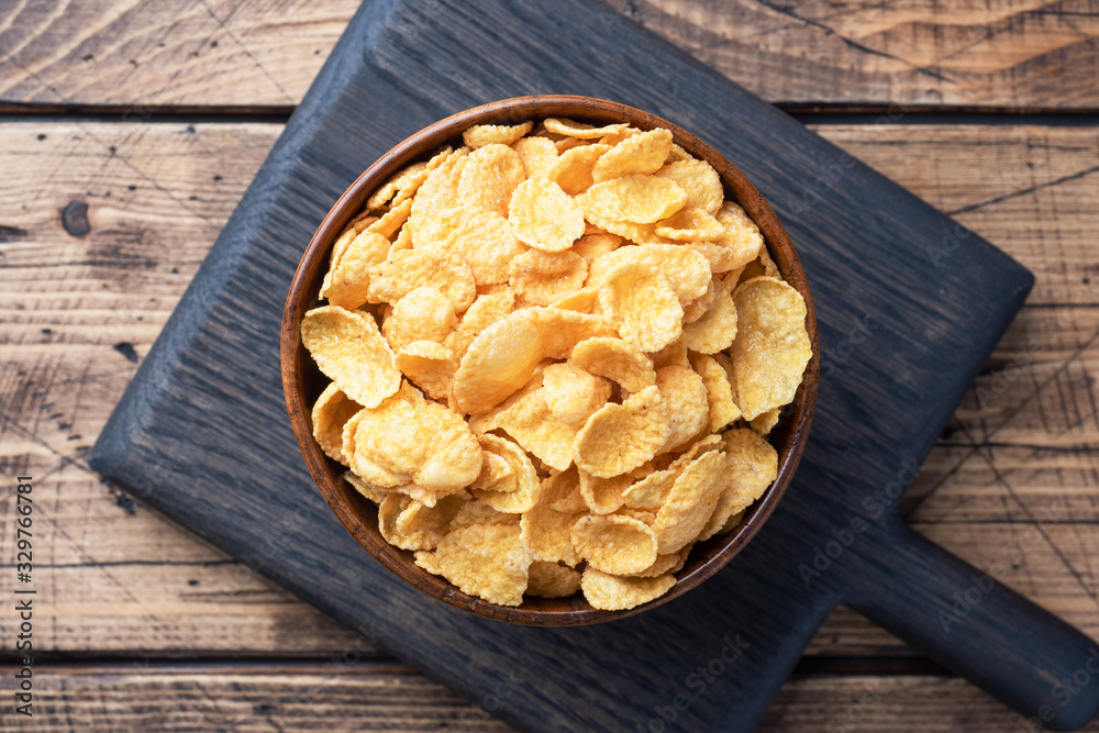 Dry flakes of corn and natural cereals for Breakfast with milk. Wooden background. Dry flakes of corn and natural cereals for Breakfast with milk. Wooden background.