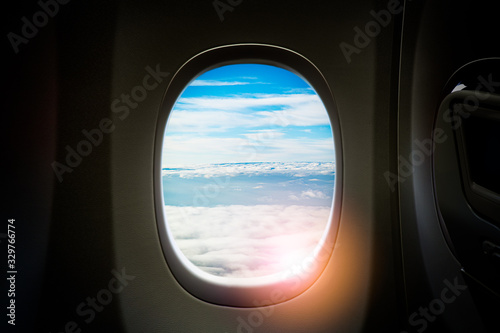 Black background with copy space look of window seat frame of airplane flight see view of clouds sky, wing travel during coronavirus risk crisis fall demand of flight cancel