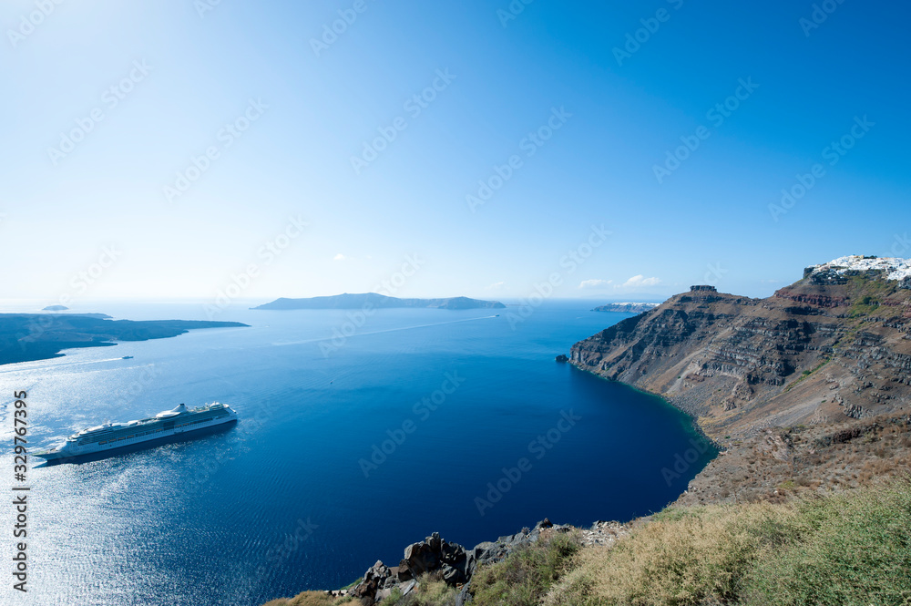 Fototapeta premium Bright scenic view of the dramatic Mediterranean caldera landscape from the cliffs of Santorini, Greece