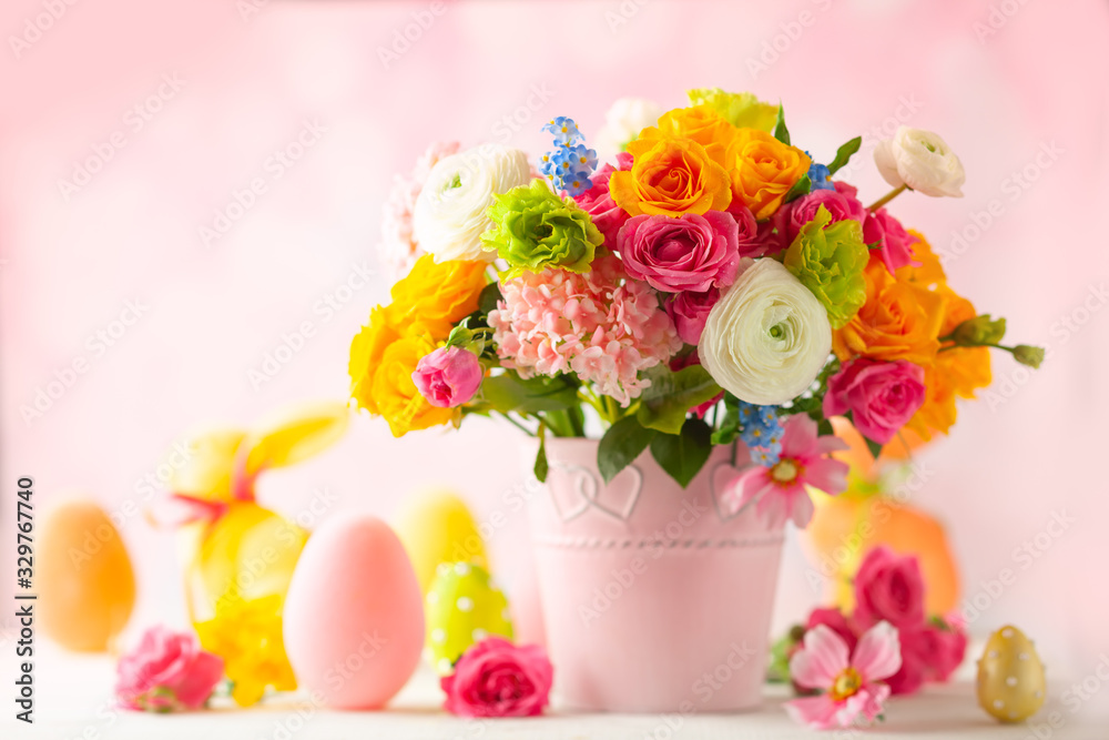 Obraz premium Easter decoration with beautiful spring flowers in vase, Easter eggs and bunny on white wooden table. Easter concept