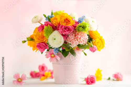 Fotografija Beautiful spring flowers in vase on white wooden table
