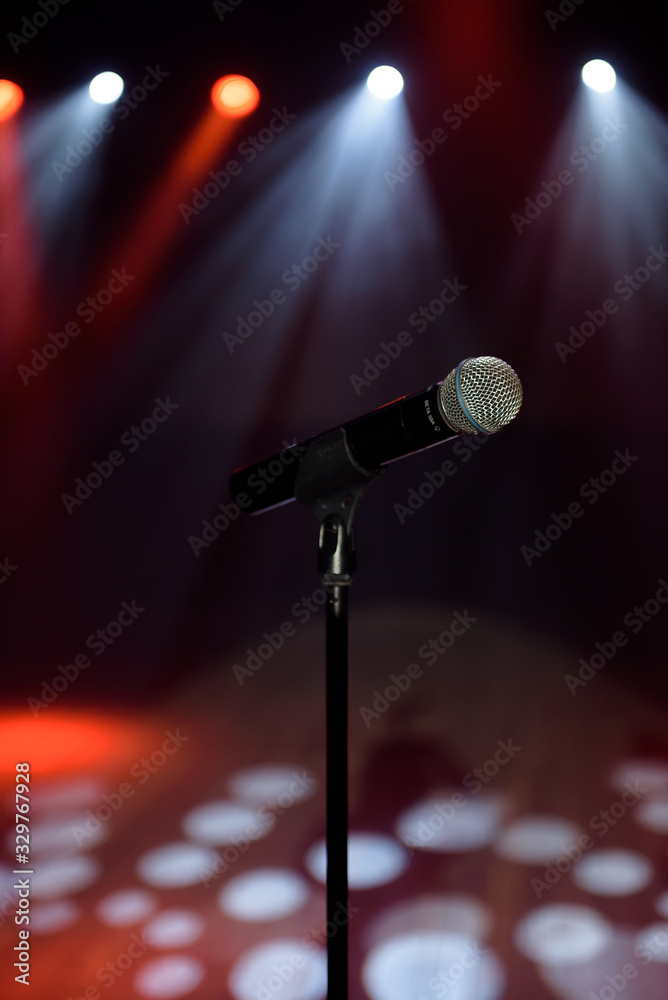 Obraz premium Close-up of microphone at concert against blur colorful light background