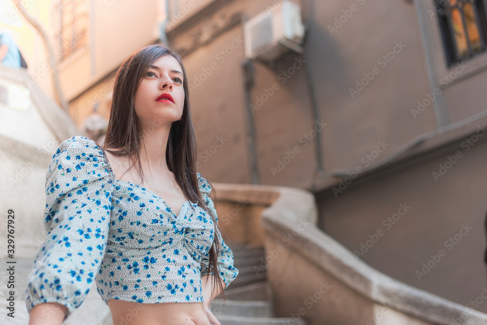 Attractive young long haired brunette woman looking to a point in a street copy space
