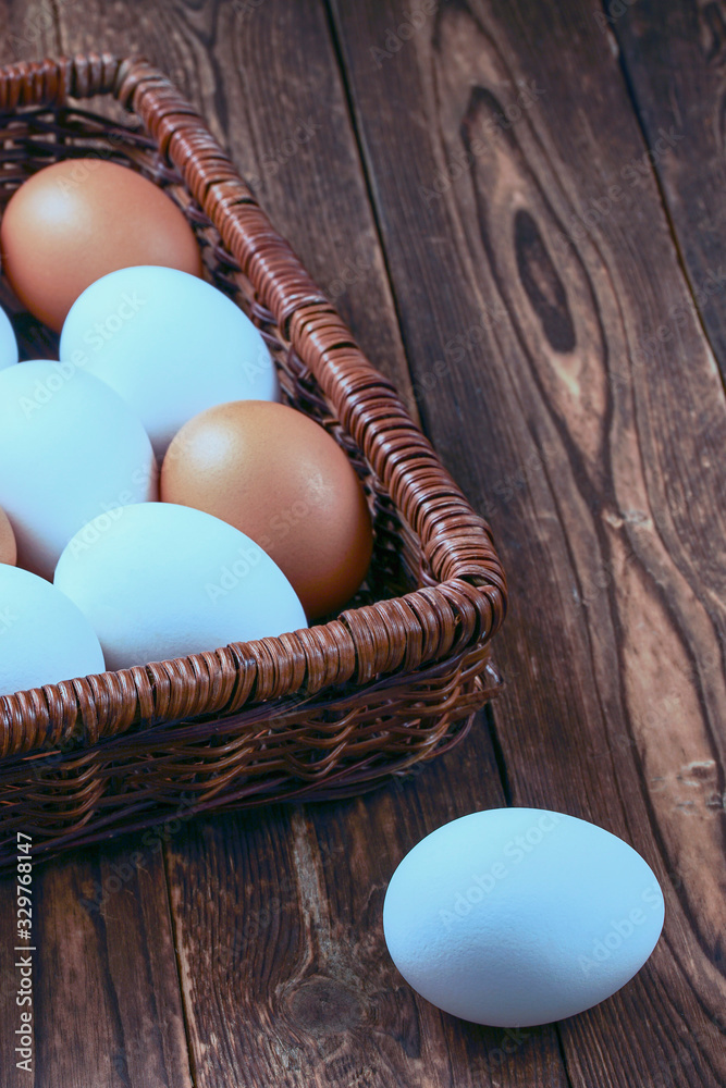 Fresh chicken eggs in a wicker basket on a dark wooden background. Healthy eating concept Fresh chicken eggs in a wicker basket on a dark wooden background. Healthy eating concept
