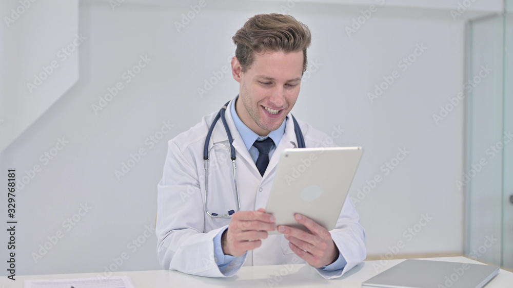 Young Male Doctor Watching Video on Tablet in Clinic