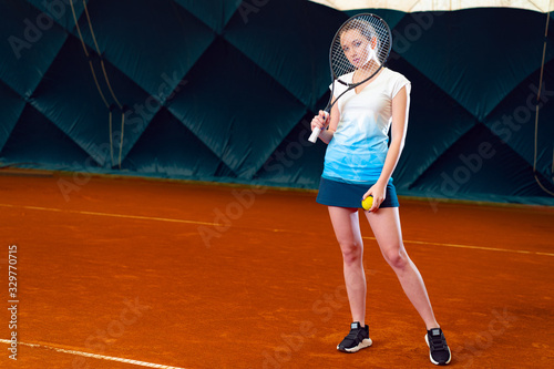 Young woman playing tennis at indoor tennis court