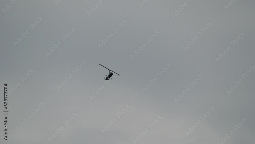 Gyroplane flying in the sky over the airfield. Aviation festival holiday at the aerodrome airport Gyroplane flying in the sky over the airfield. Aviation festival holiday at the aerodrome airport