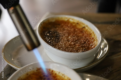Obraz na plátně Preparation of a crème brûlée in a restaurant