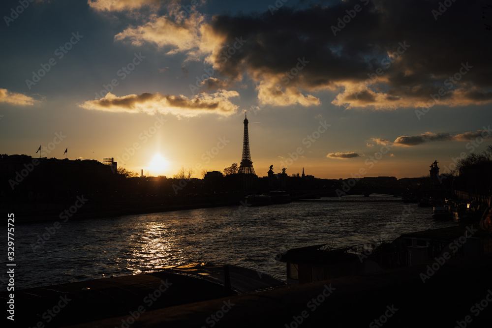 Spectacular romantic sunset. Eiffel Tower with boats on Seine river in Paris, France. Eiffel Tower from a less usual angle. Evening in Paris, France.