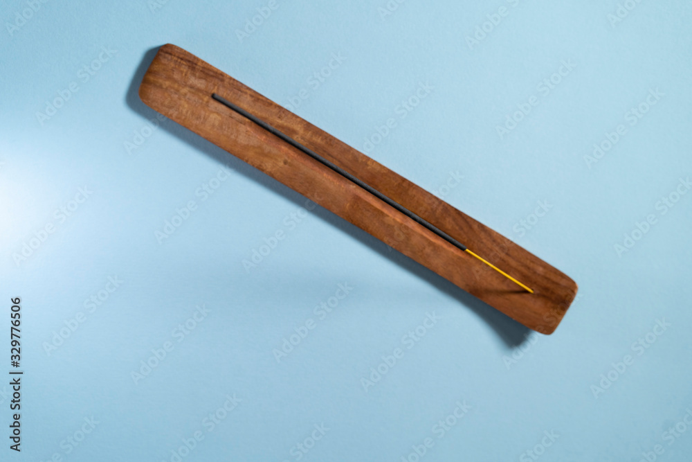 Aromatic stick in a beautiful wooden stand on a blue background. Copyspace for your text Aromatic stick in a beautiful wooden stand on a blue background. Copyspace for your text
