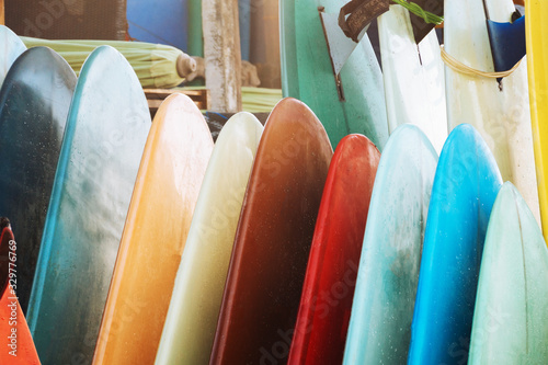 Close up Set of colorful surfboard for rent on the beach. Multicolored surf boards different sizes and colors surfing boards on stand, surfboards rental place © tatyanasuyarova