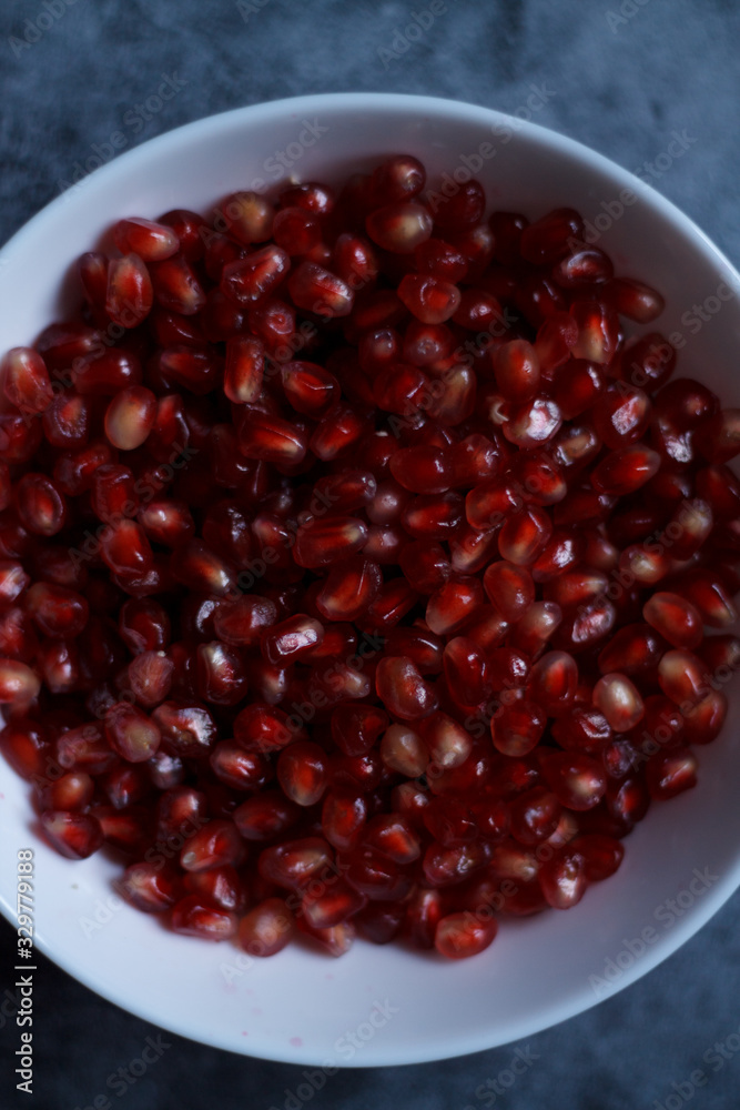 pomegranate berries are red close-up on a dark blue background. cut garnet with blurred background pomegranate berries are red close-up on a dark blue background. cut garnet with blurred background