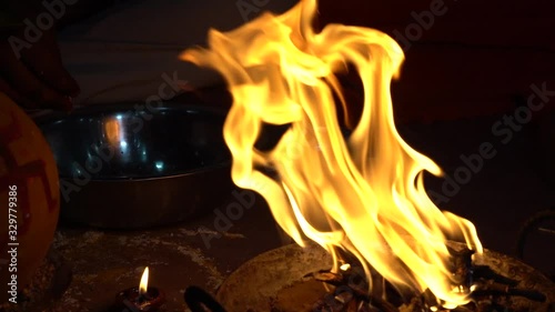 Slow motion of a devotee putting havan samigri into the havan kund. Slow motion. Close up. photo