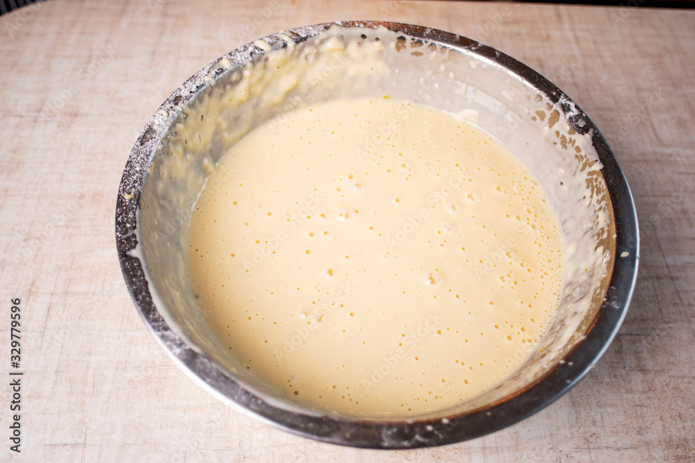 Dough for crepes or pancakes in glass bowl top view