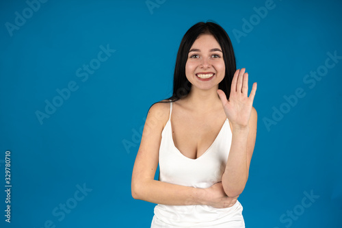 Front view of laughing girl showing palm isolated on blue background © Ivan
