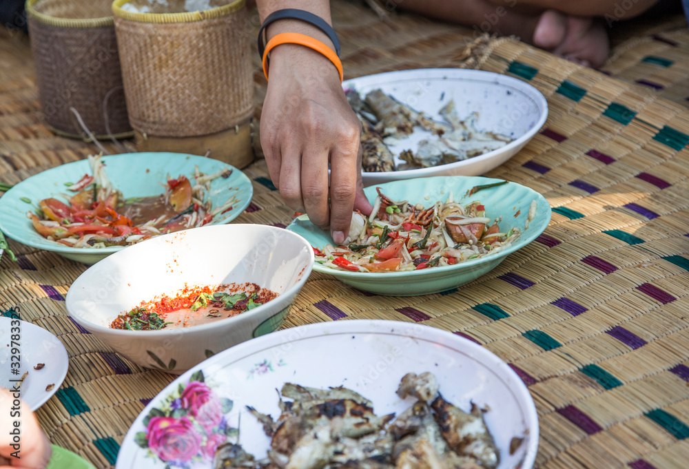 eating noreasthern food menu with hand on rattan mat eating noreasthern food menu with hand on rattan mat