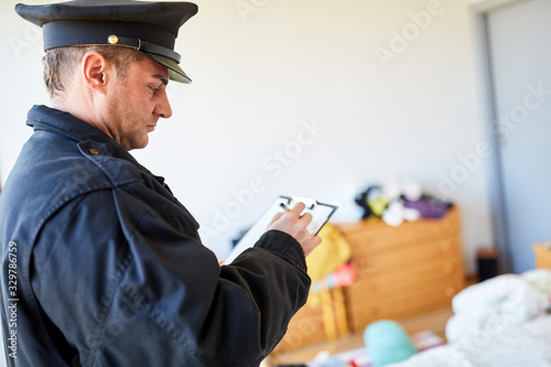 Polizist der Kriminalpolizei am Tatort nach Einbruch photo