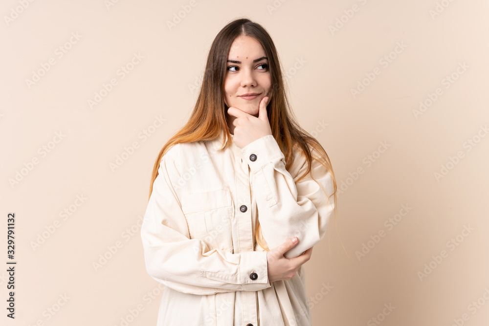 Young caucasian woman isolated on beige background thinking an idea while looking up Young caucasian woman isolated on beige background thinking an idea while looking up