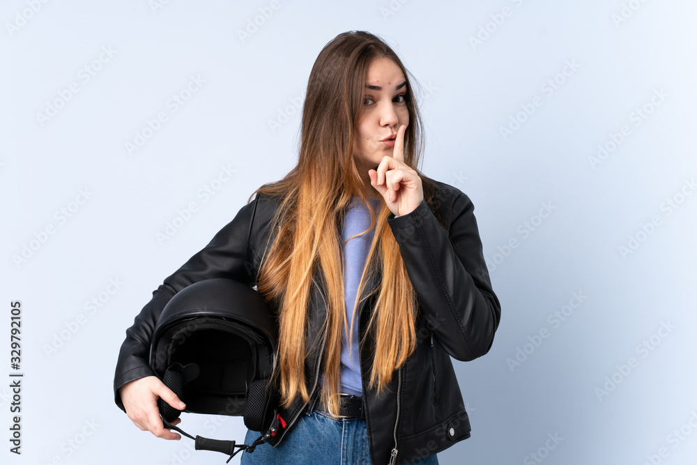 Woman with a motorcycle helmet doing silence gesture Woman with a motorcycle helmet doing silence gesture