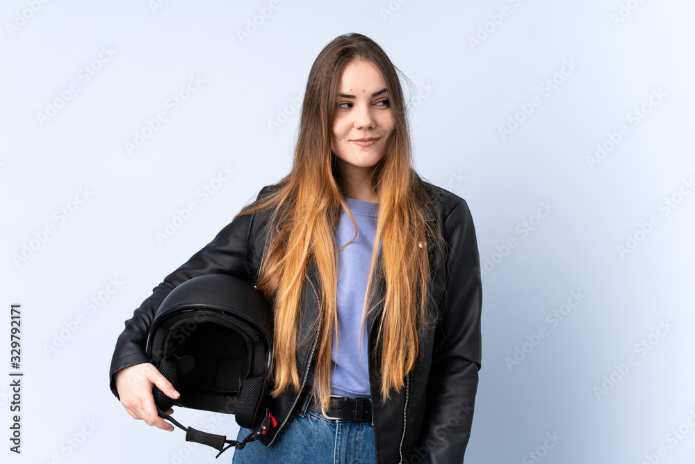 Woman with a motorcycle helmet standing and looking to the side Woman with a motorcycle helmet standing and looking to the side