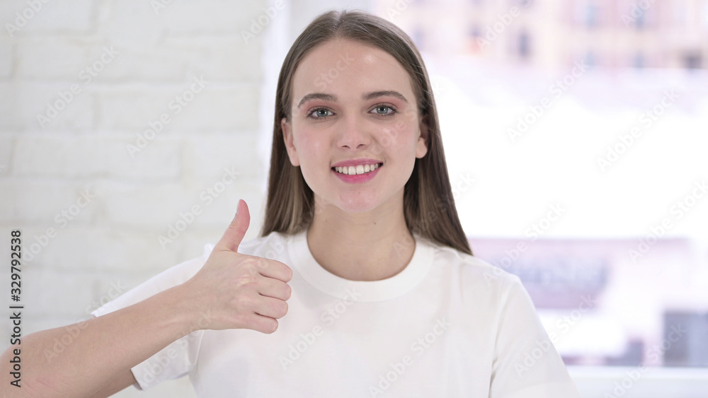 Portrait of Beautiful Young Woman doing Thumbs Up in Office