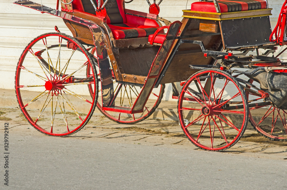 Beautiful red wheels of old wagon on the road