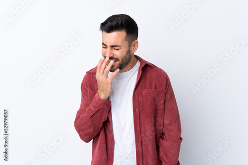 Young handsome man with beard wearing a corduroy jacket over isolated white background smiling a lot