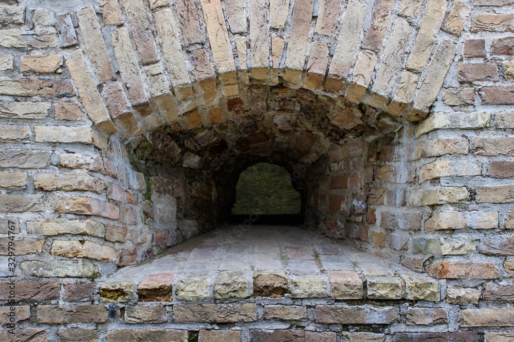 Small window embrasure in the old ancient historical brick wall. Small window embrasure in the old ancient historical brick wall.