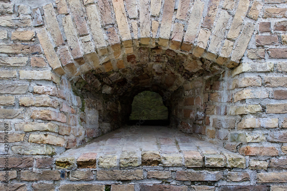 Small window embrasure in the old ancient historical brick wall.