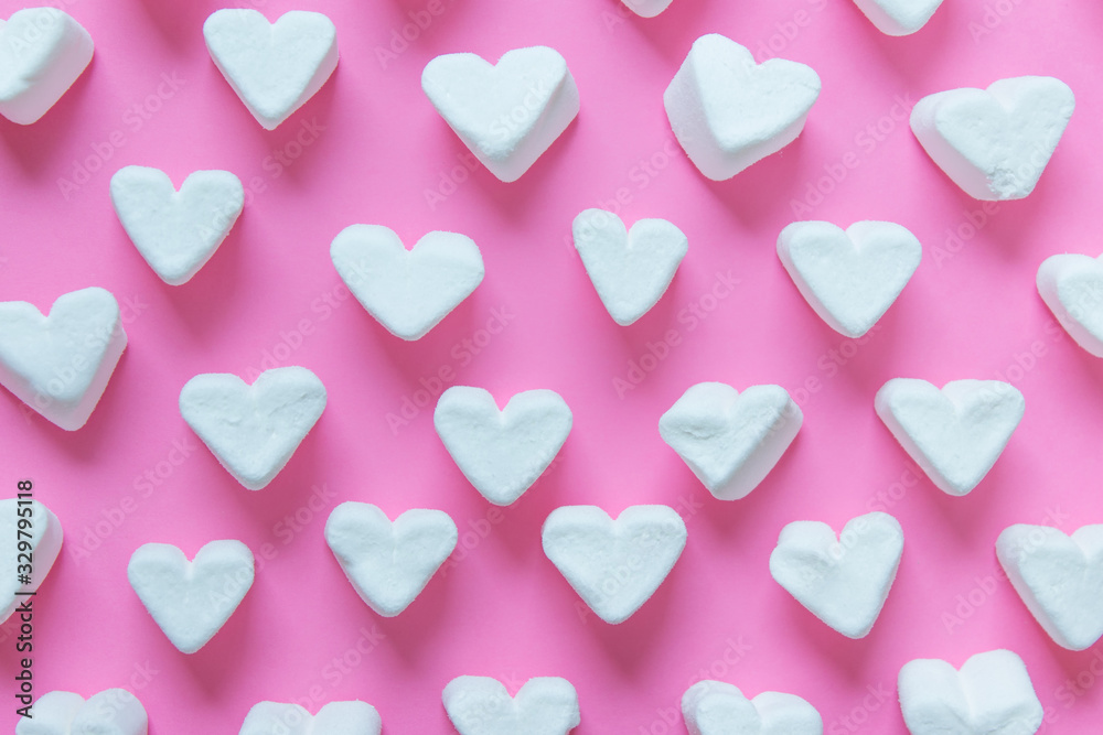 Pattern made with heart shaped white sweet marshmallows on pink background. 3d illustration.