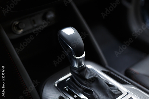 Selector automatic transmission with leather in the interior of a modern expensive car. The background is blurred. Black leather car interior. Luxurious car instrument cluster. Close up shot