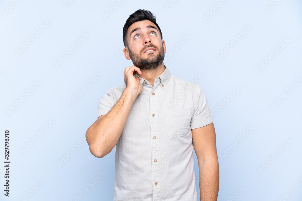 Young handsome man with beard over isolated blue background thinking an idea Young handsome man with beard over isolated blue background thinking an idea