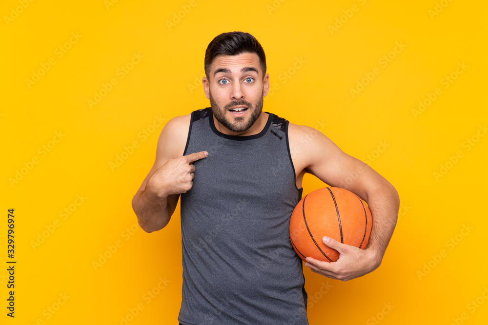 Handsome young basketball player man over isolated white wall with surprise facial expression