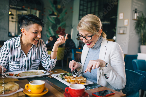 woman friends on breakfast in restaurant talking