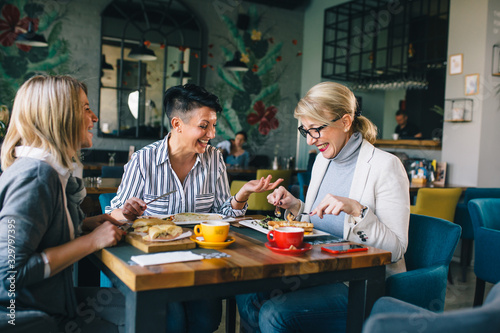 woman friends on breakfast in restaurant talking