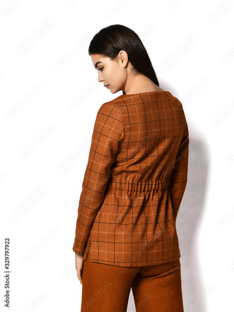 Φωτογραφία Young brunette woman in stylish business suit trousers and jacket is standing ba
