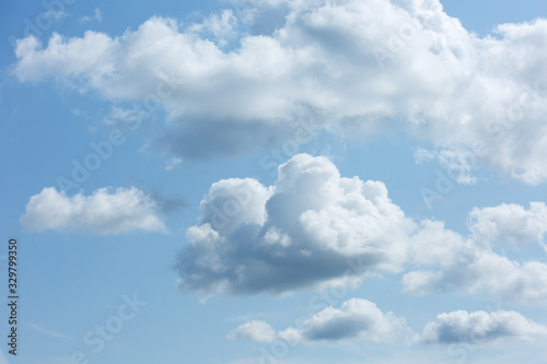 A large cluster of white Cumulus clouds in a blue sky.