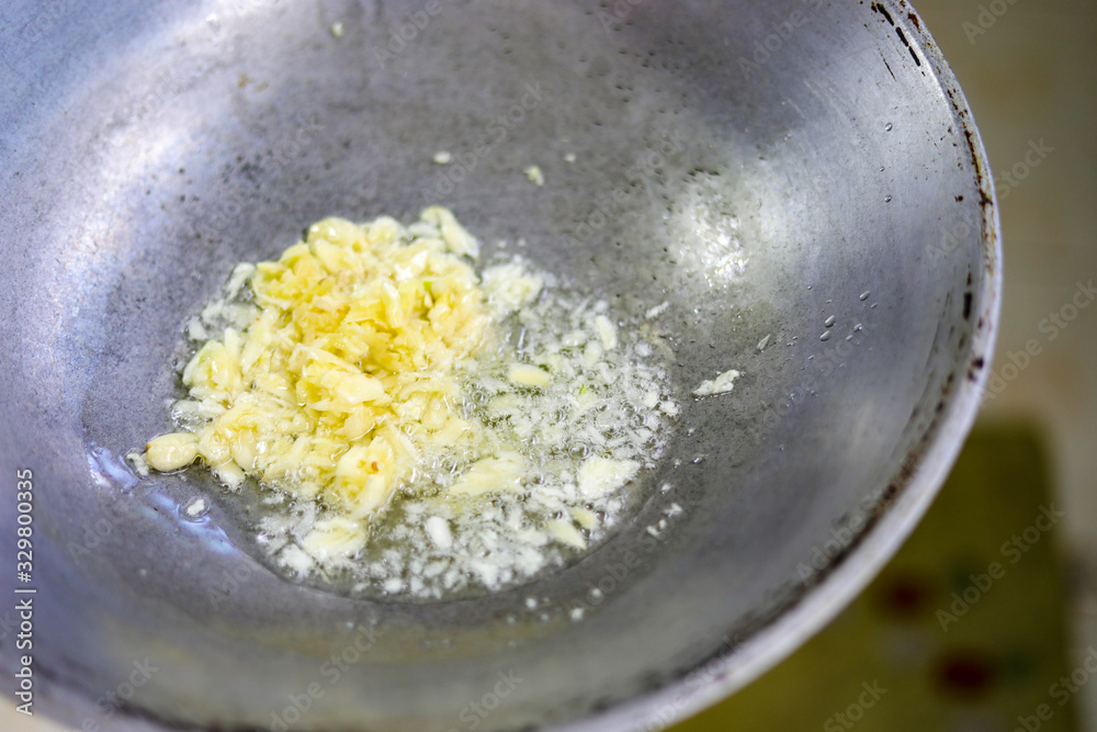 Fotografie Garlic fried in a hot pan