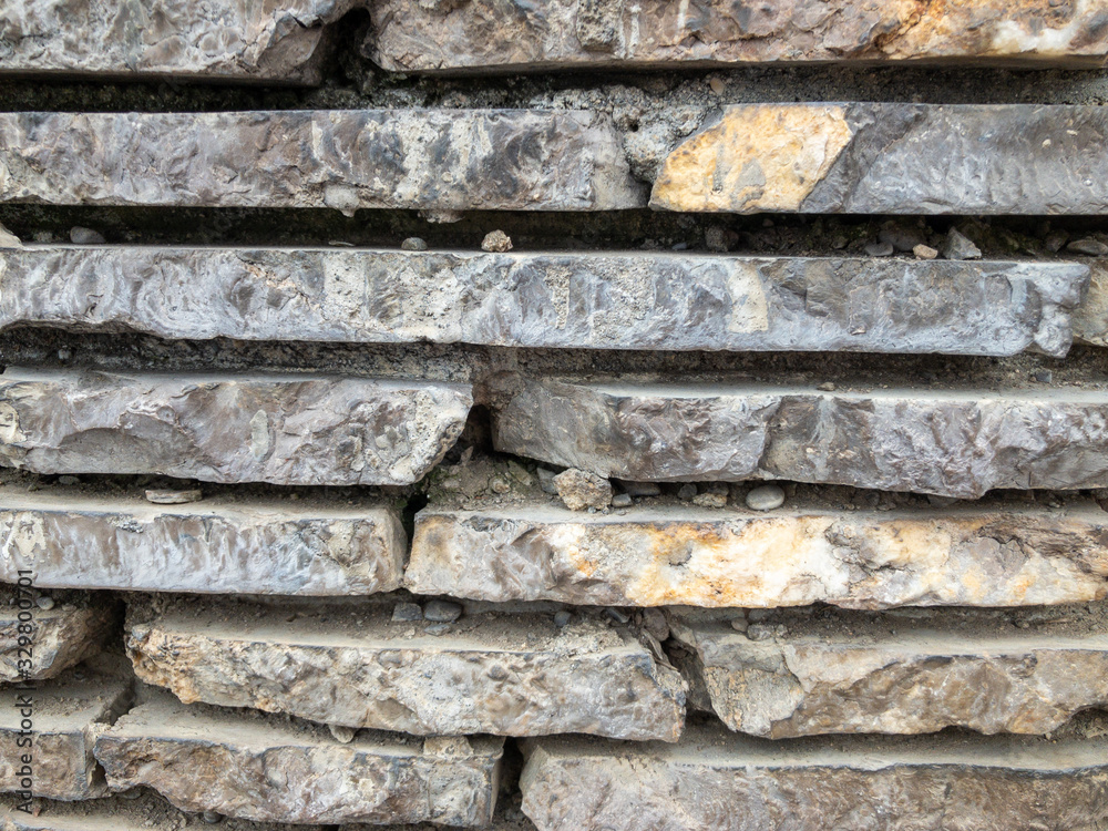 Naklejka premium The surface of a stone wall. Masonry walls of old stone blocks.