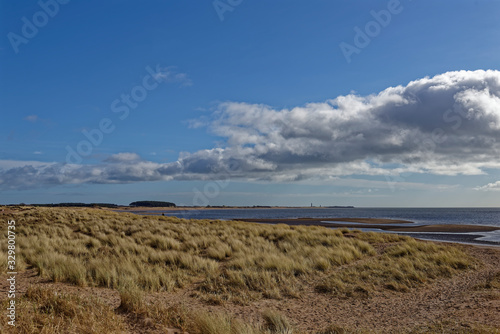 Looking towards the Barry Buddon Headland from Monifieth Beach with its low grass covered dunes behind the gently shelving Sandy Beach.