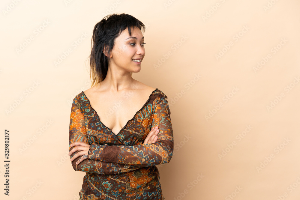 Indian woman isolated on beige background looking to the side Indian woman isolated on beige background looking to the side